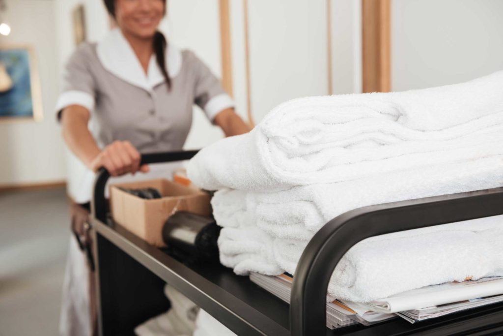 Cropped image of a young hotel maid bringing clean towels