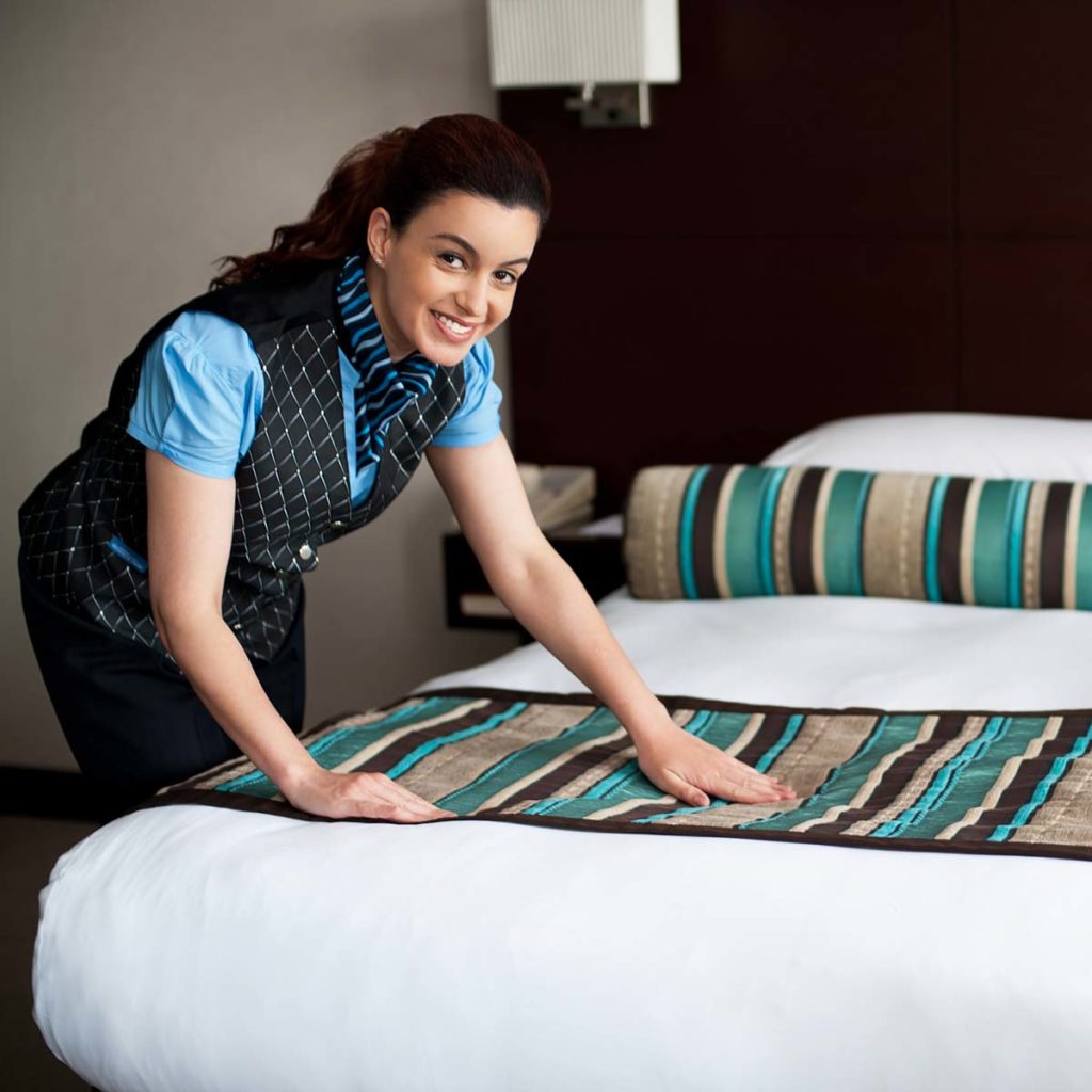 hotel person making a bed